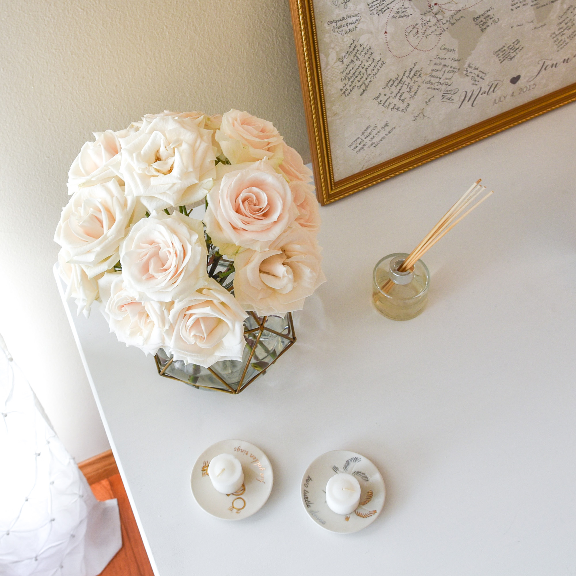 white roses in gold vase 