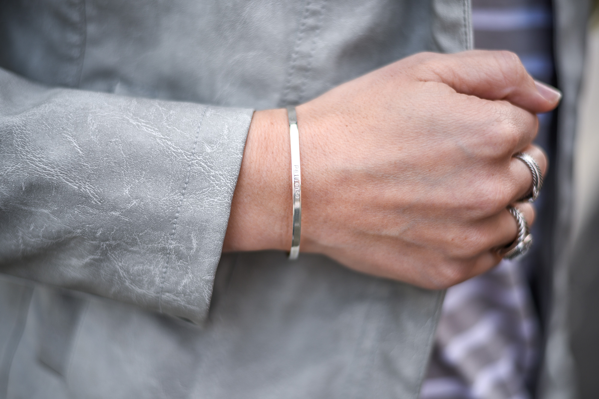 silver cuff with the word "patience" inscribed