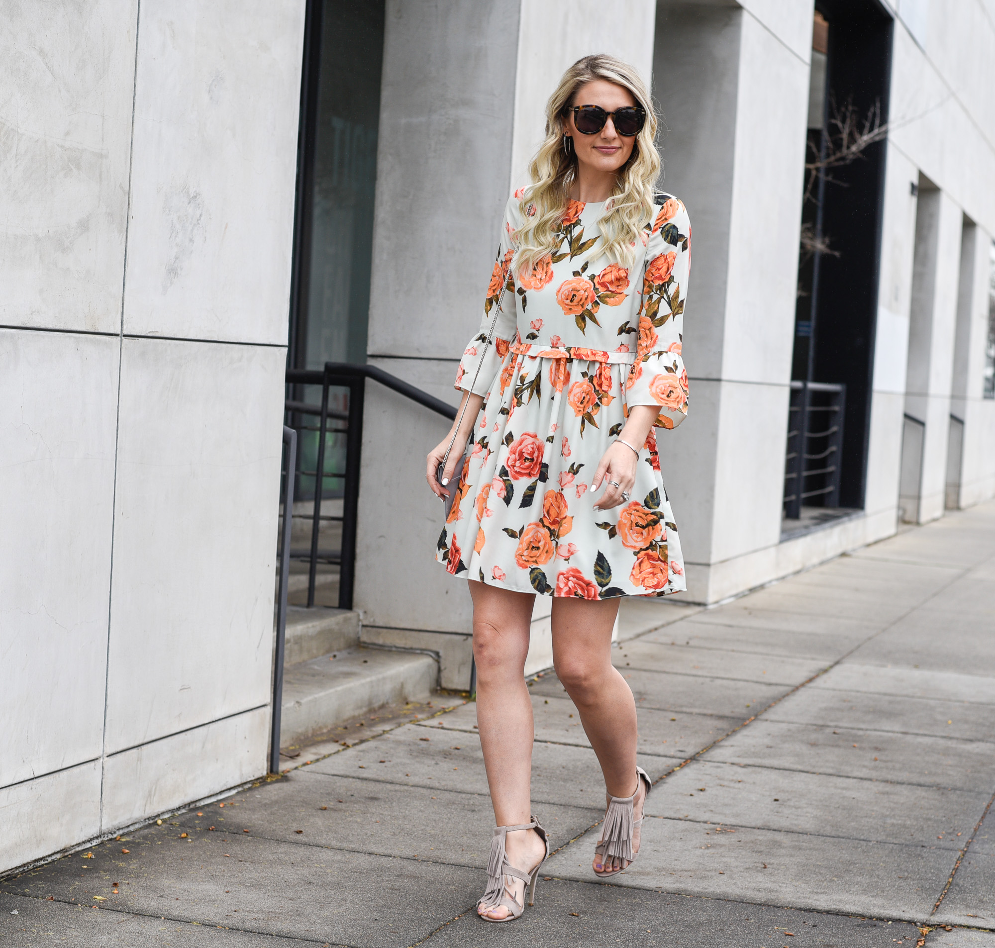 Jenna Colgrove wearing a floral bell sleeve dress that is perfect for wedding season. 