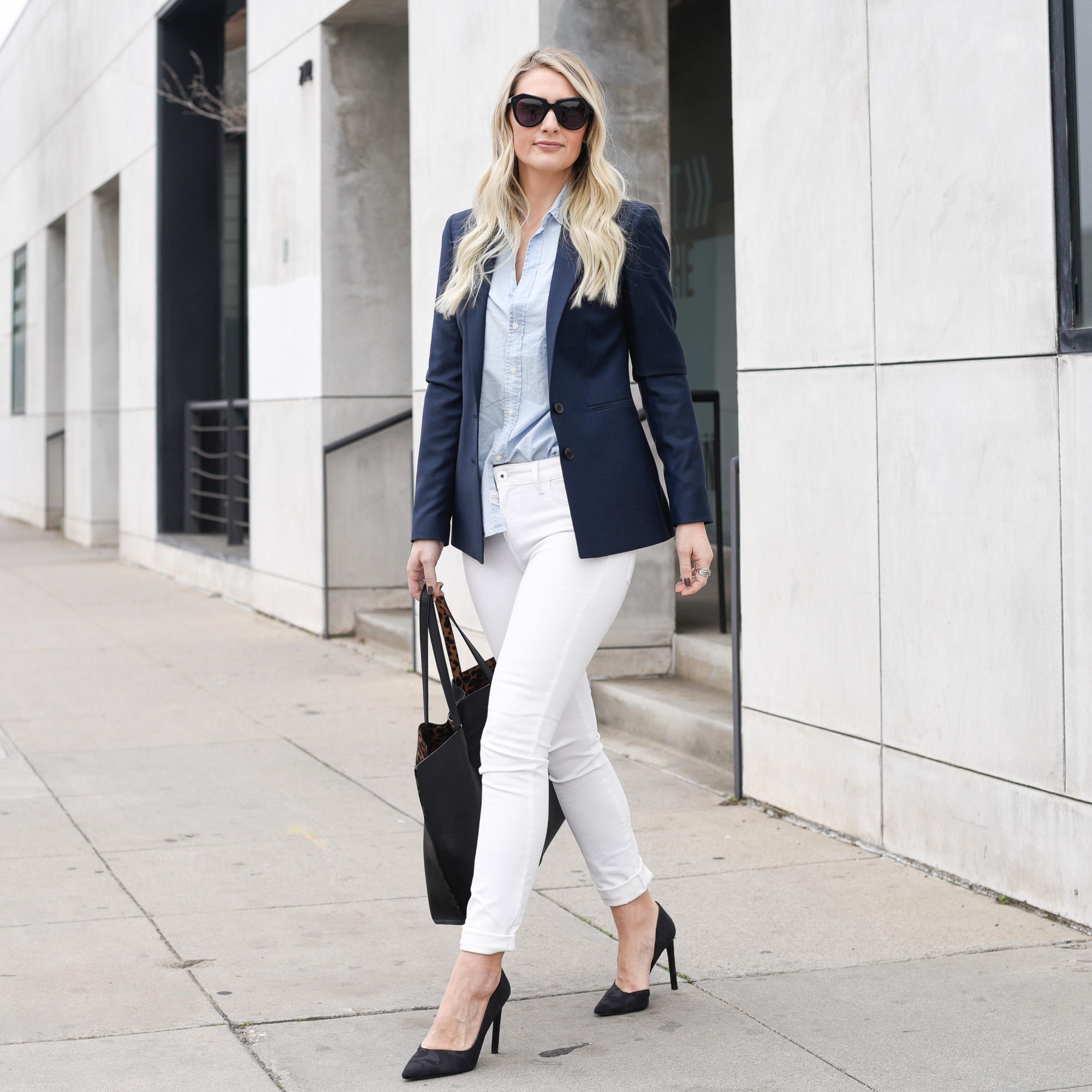 Jenna Colgrove wearing a navy blazer, chambray button down, and white skinny jeans. 