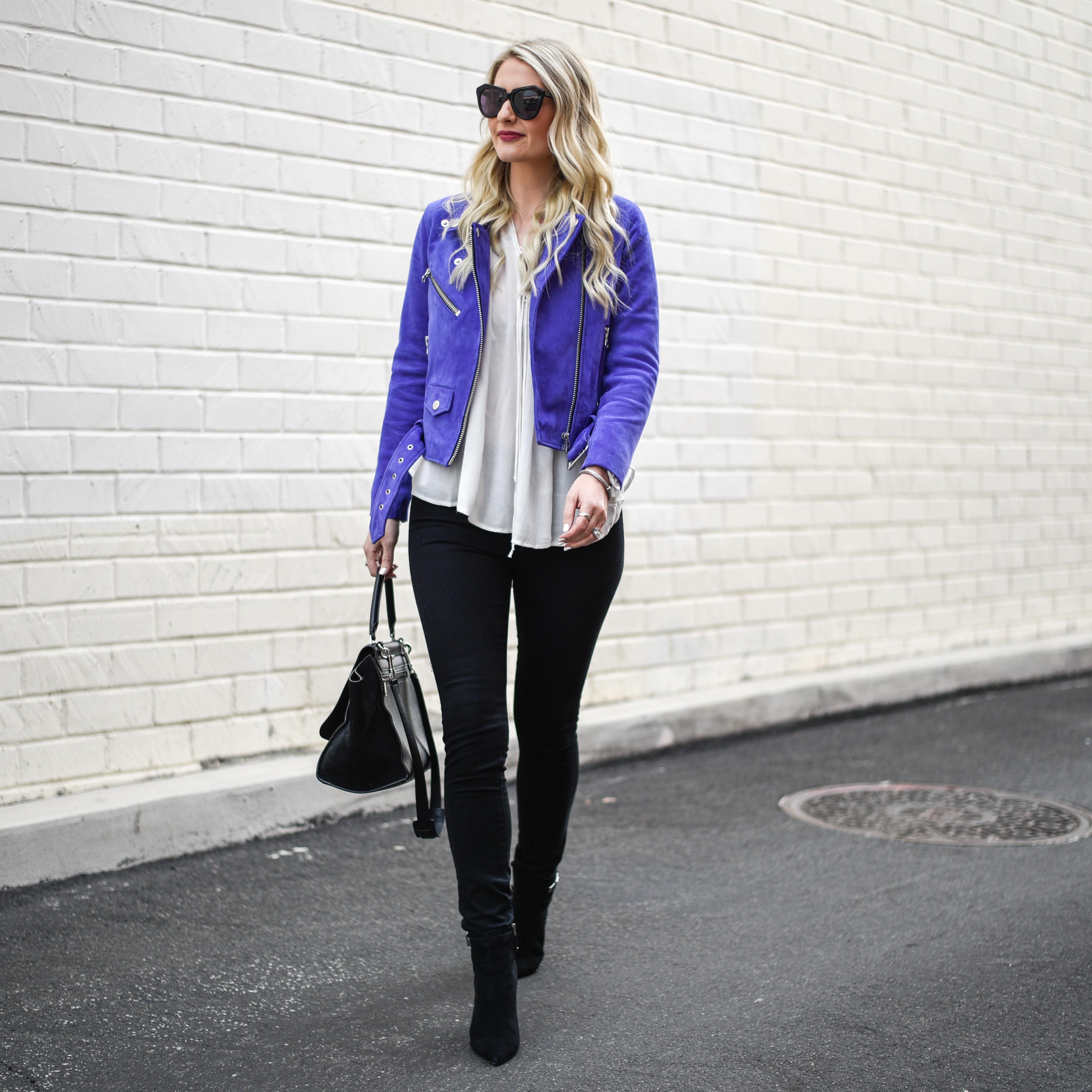 Jenna Colgrove wearing black skinny jeans and a purple suede jacket. 