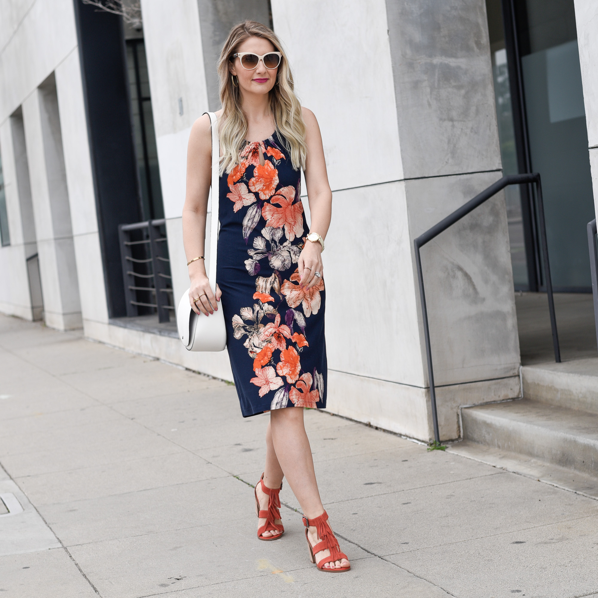 Jenna Colgrove wearing a navy botanical dress with coral accents. 