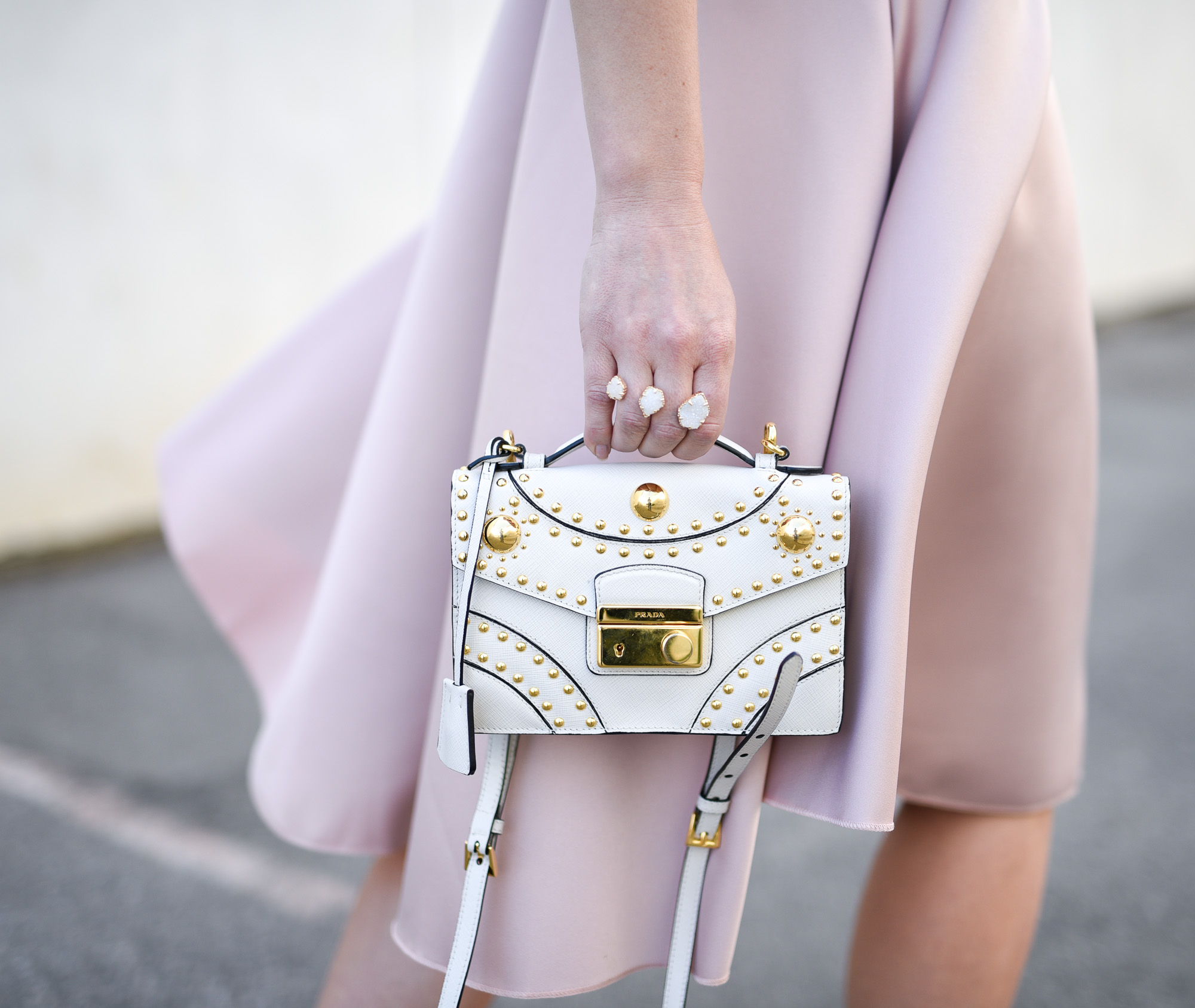 A white and gold Prada crossbody back with detachable straps.