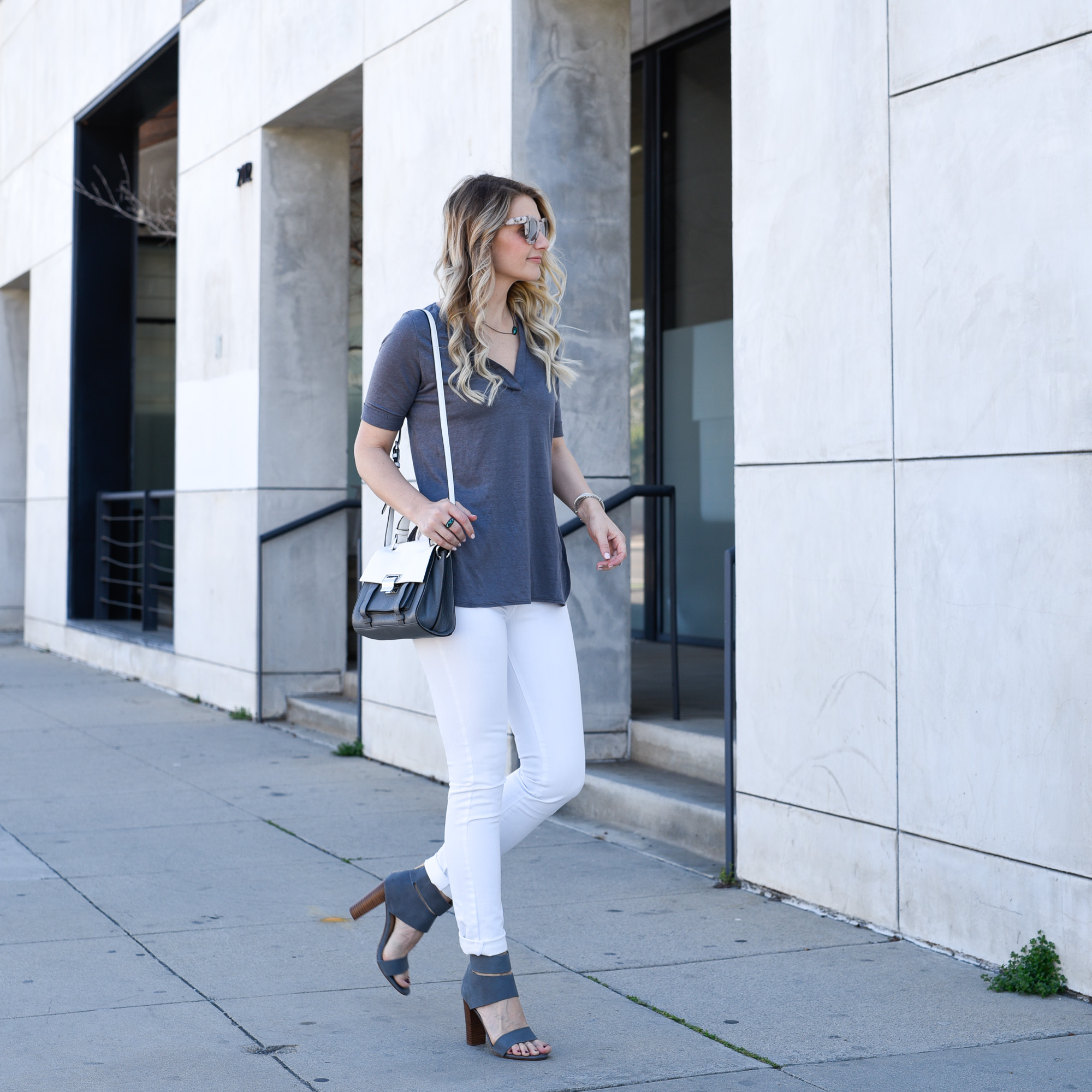 A grey linen top with white jeans that flatter all figures. 
