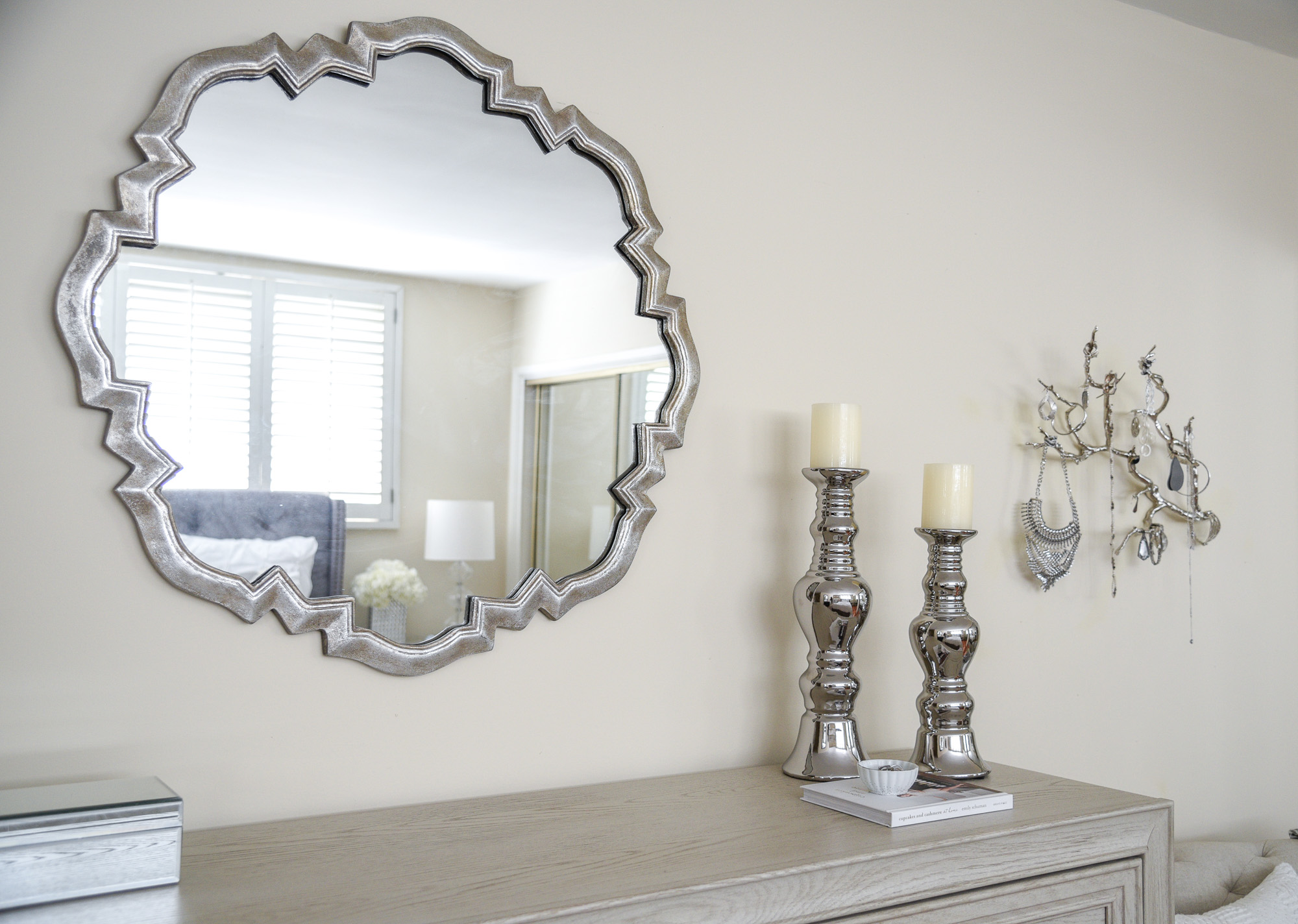 scalloped mirror with decorative silver candle holders 