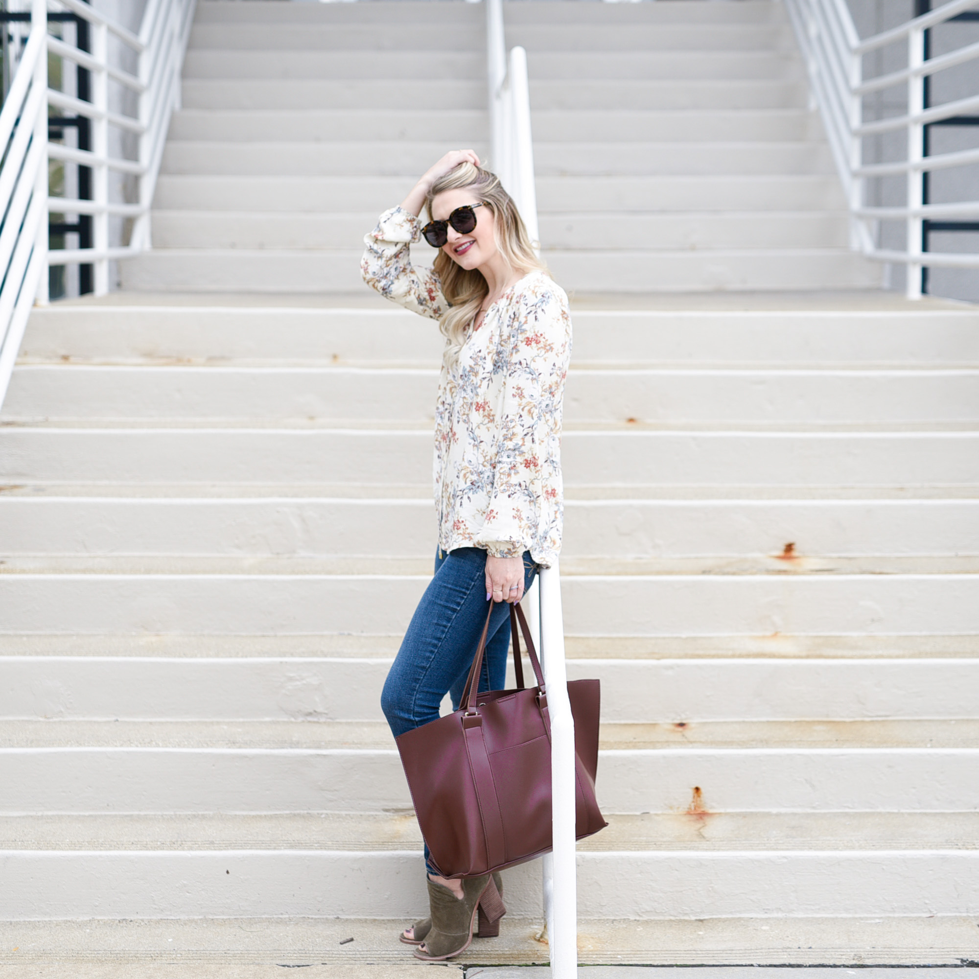 Jenna Colgrove wearing a pre-fall outfit: floral peasant top, skinny jeans, and suede booties with a carry all tote.