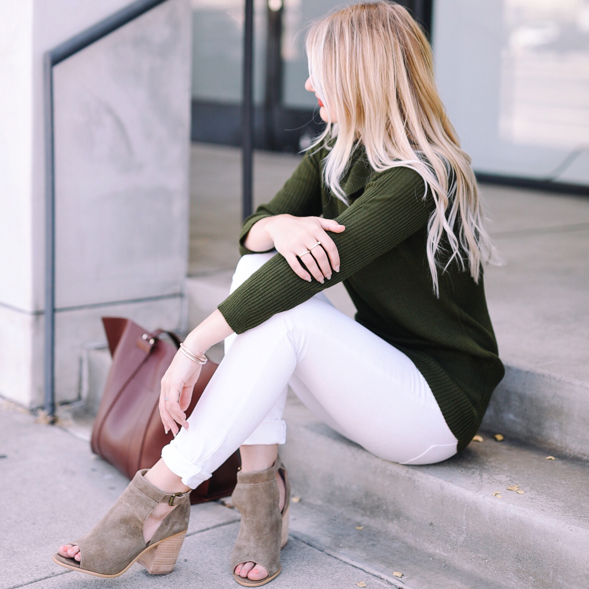 Jenna Colgrove wearing the Sole Society Ferries Open Toe Bootie and a green sweater. 