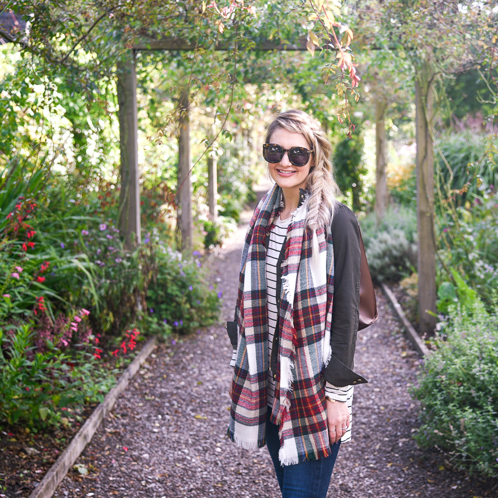 Jenna Colgrove wearing a Nordstrom red plaid scarf, striped tee, and olive military jacket. 