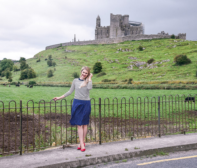 Jenna Colgrove wearing a navy striped sweater and polka dotted skirt in Ireland. 