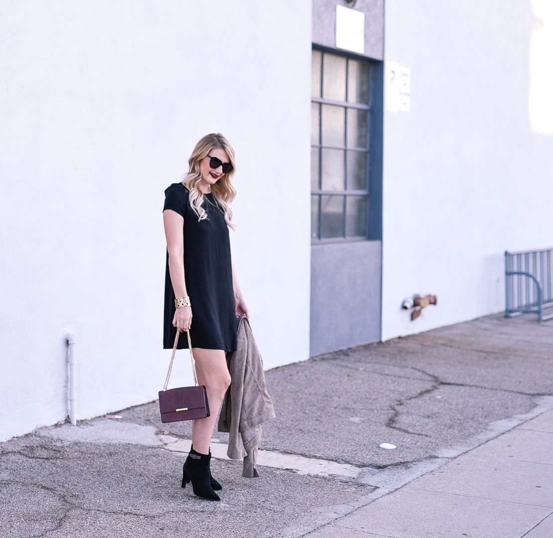 Jenna Colgrove wearing Elvio Zanon black booties and a burgundy python print shoulder bag by Ivanka Trump. 