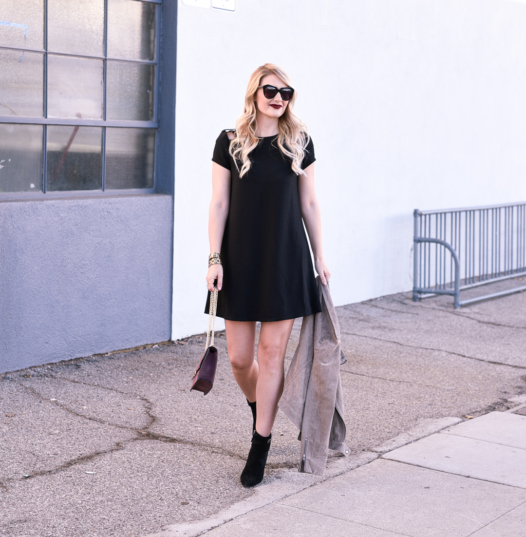Jenna Colgrove wearing a little black dress with shoulder cut outs and black boots. 