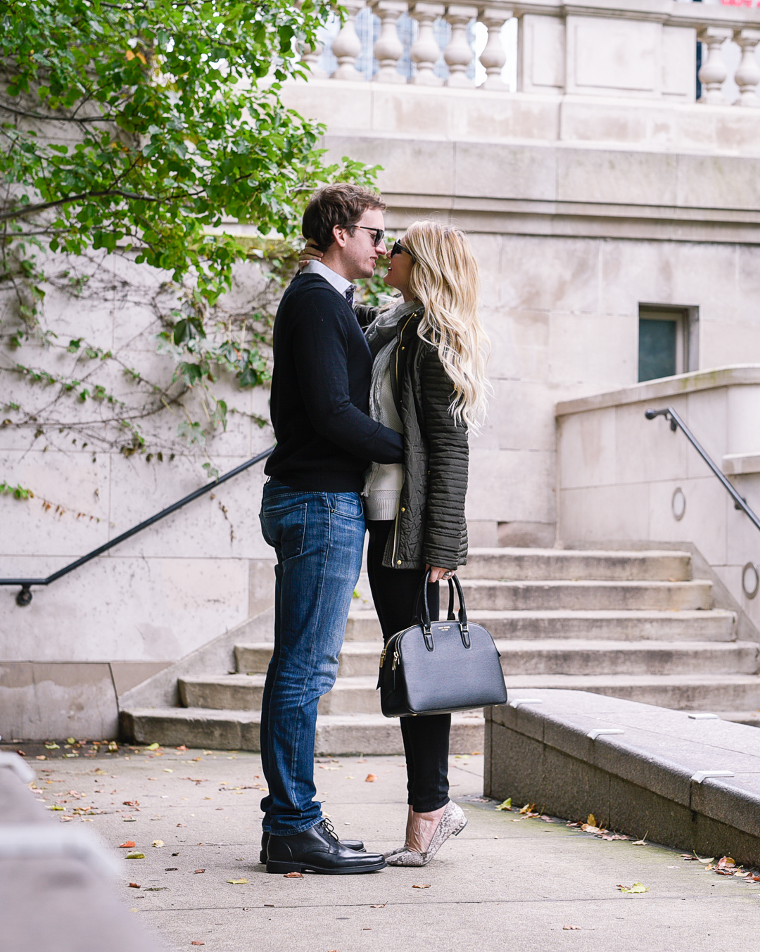 Couple stealing kisses in the city of Chicago on the riverwalk.