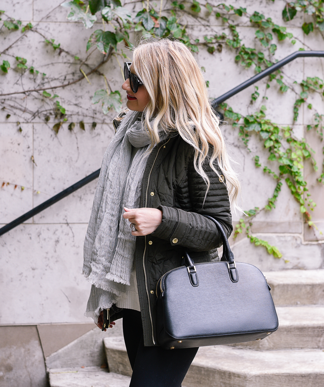 Jenna Colgrove wearing a black Henri Bendel crossbody, a hunter green coat, and in wand curls. - best winter coats for women by Chicago fashion blogger Visions of Vogue