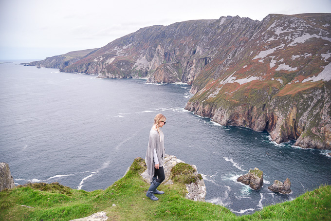 Jenna Colgrove wearing Spanx faux leather leggings and grey matte Hunter Boots at Slieve League, Ireland. 