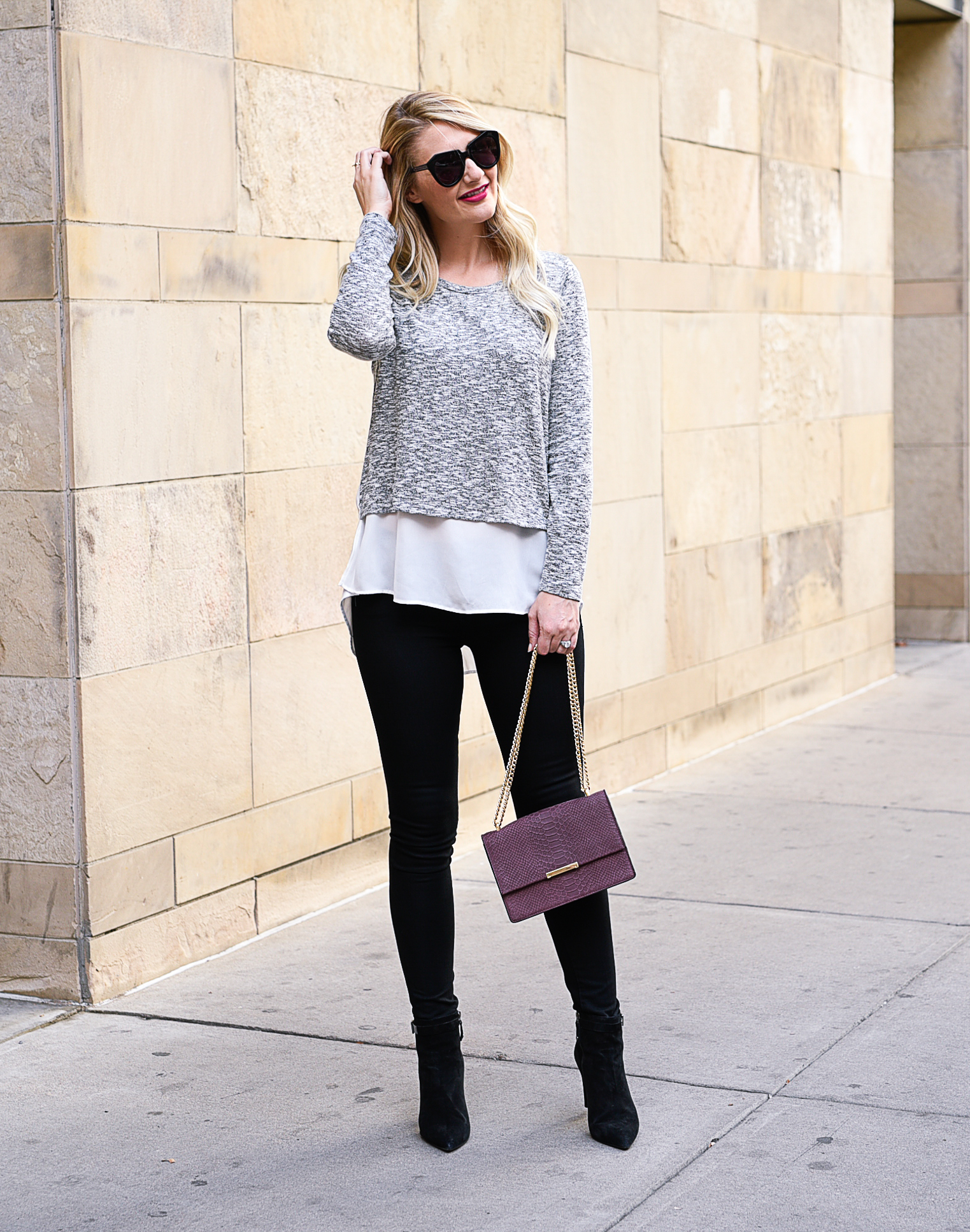 Jenna Colgrove wearing a Gibson Mixed Media layered blouse, black skinny jeans, and the Ivanka Trump Mara cocktail back in burgundy. 