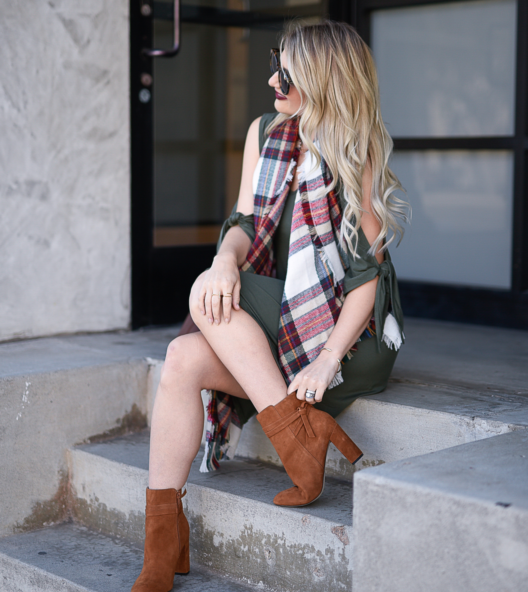 Jenna Colgrove wearing an olive dress, Sole Society cognac booties, and a plaid blanket scarf. 