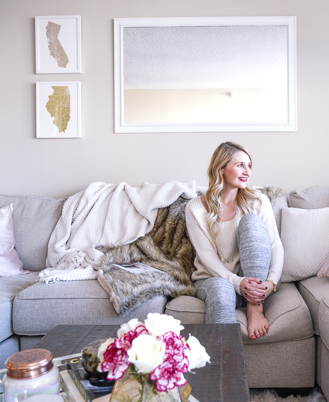 Jenna Colgrove cozying up on the Wilcot couch with a fur blanket and a knit throw. 