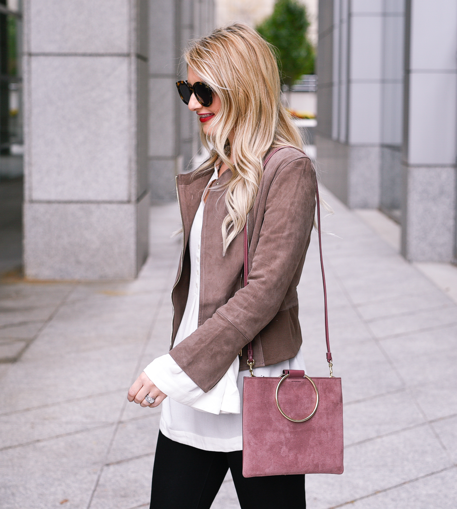 Jenna Colgrove wearing a suede jacket and blush crossbody bag.