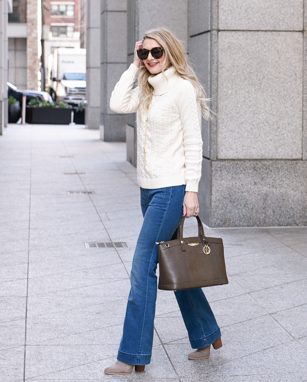 Jenna Colgrove wearing flared jeans and a cozy white sweater for winter.