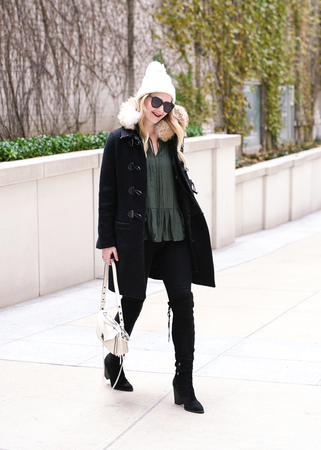 Jenna Colgrove wearing the Vail Parka and a dark green peplum top. 