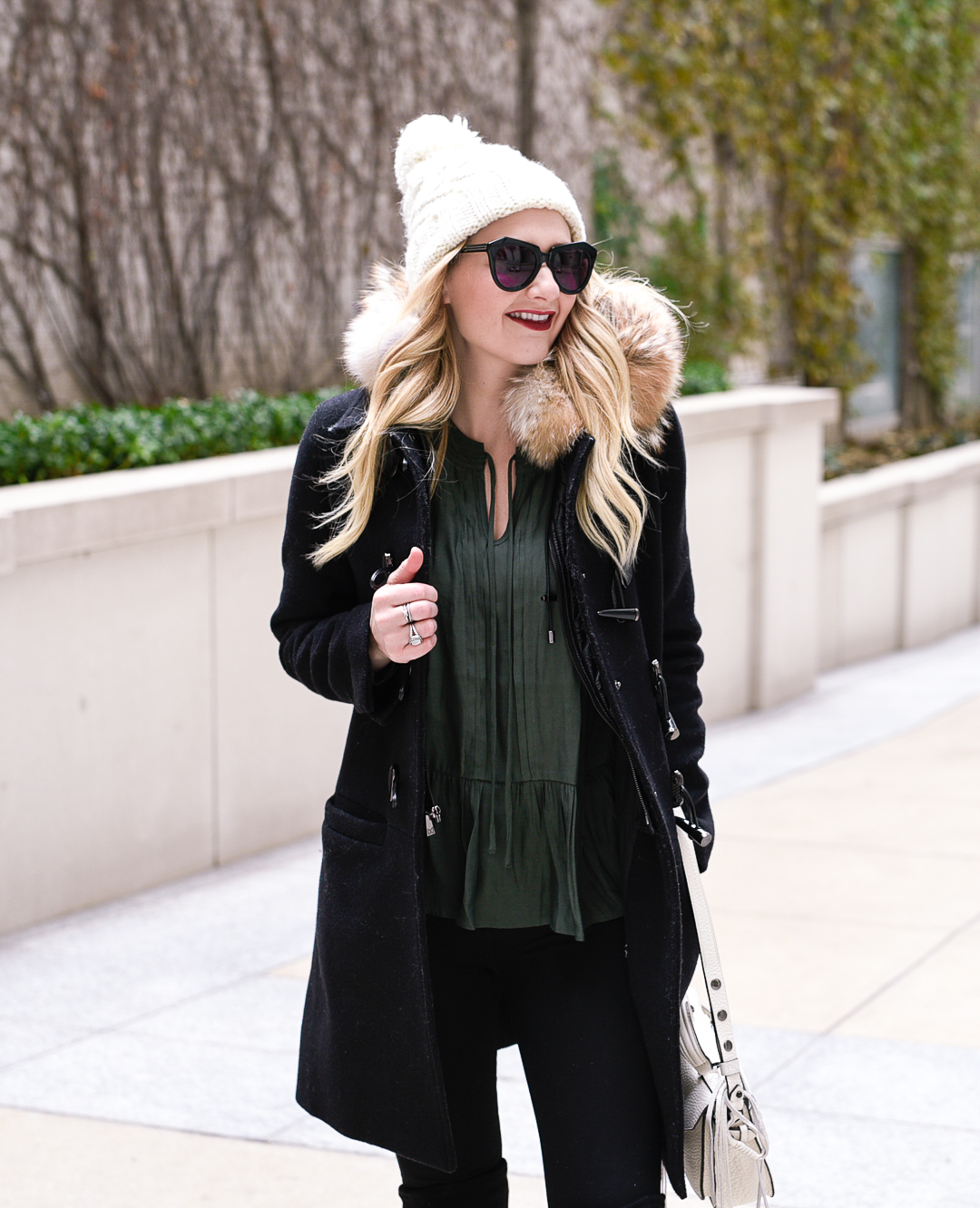 Ready for winter in this white pom beanie and green peplum top. 