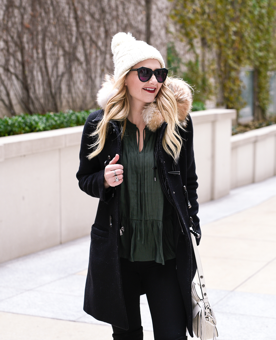 Ready for winter in this white pom beanie and green peplum top.