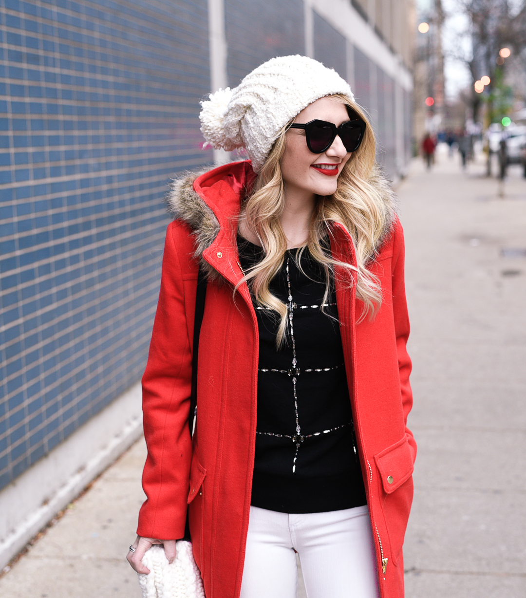 Black knit sweater with bejeweled embellishments and a Free People pom beanie.