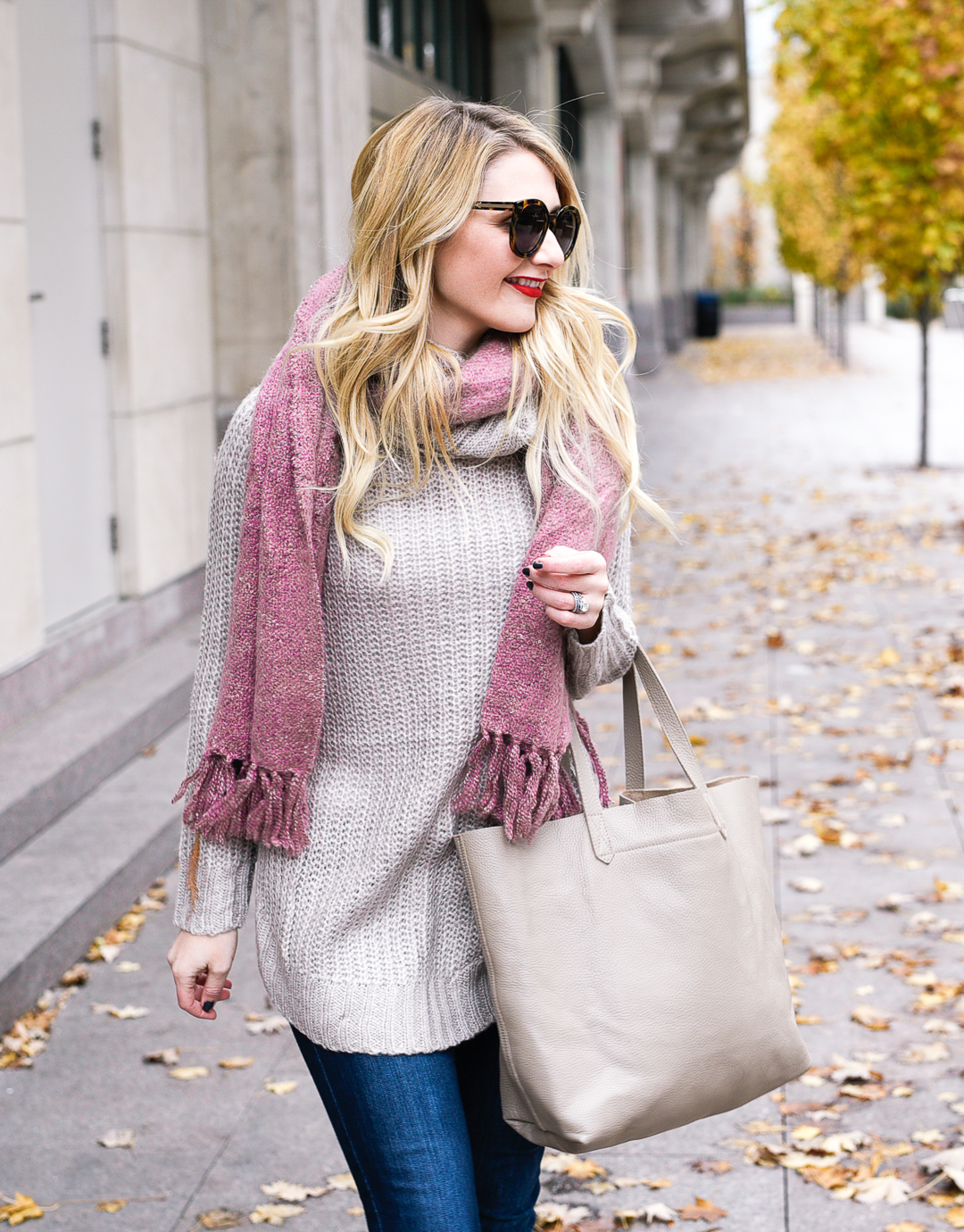 Taupe tunic and a pink fringe knit scarf.