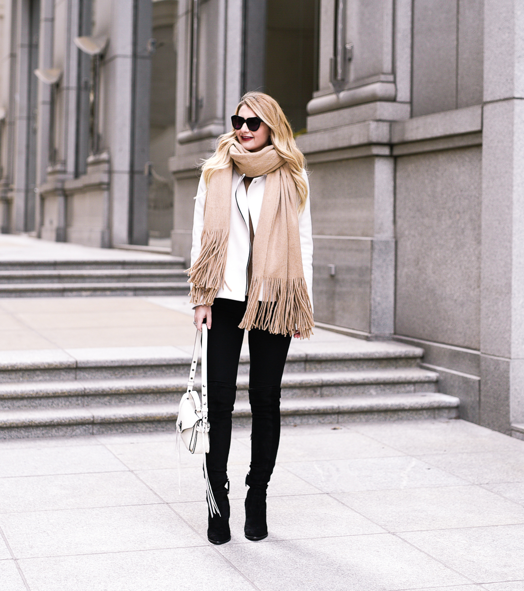 White moto jacket, camel fringe scarf, and black over the knee boots. 