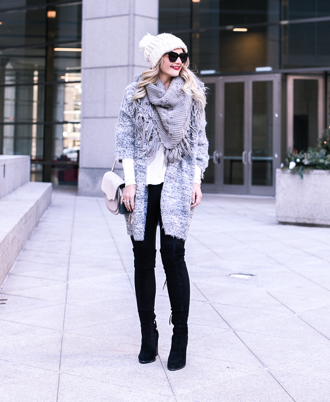 Black over the knee boots, leather leggings, and a grey fringe wrap. 