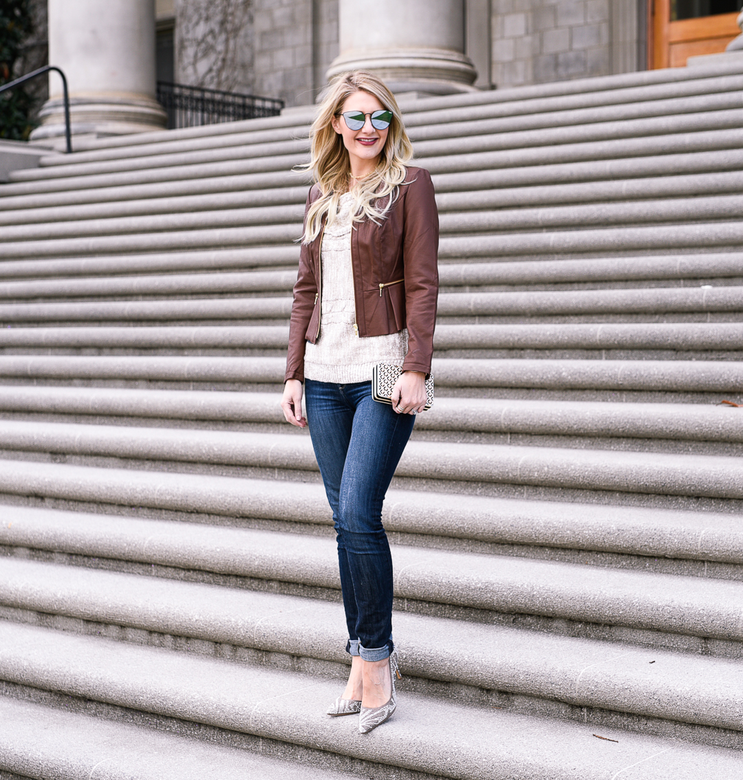 Leather moto jacket, dark wash denim, and beige knit off the shoulder sweater. 