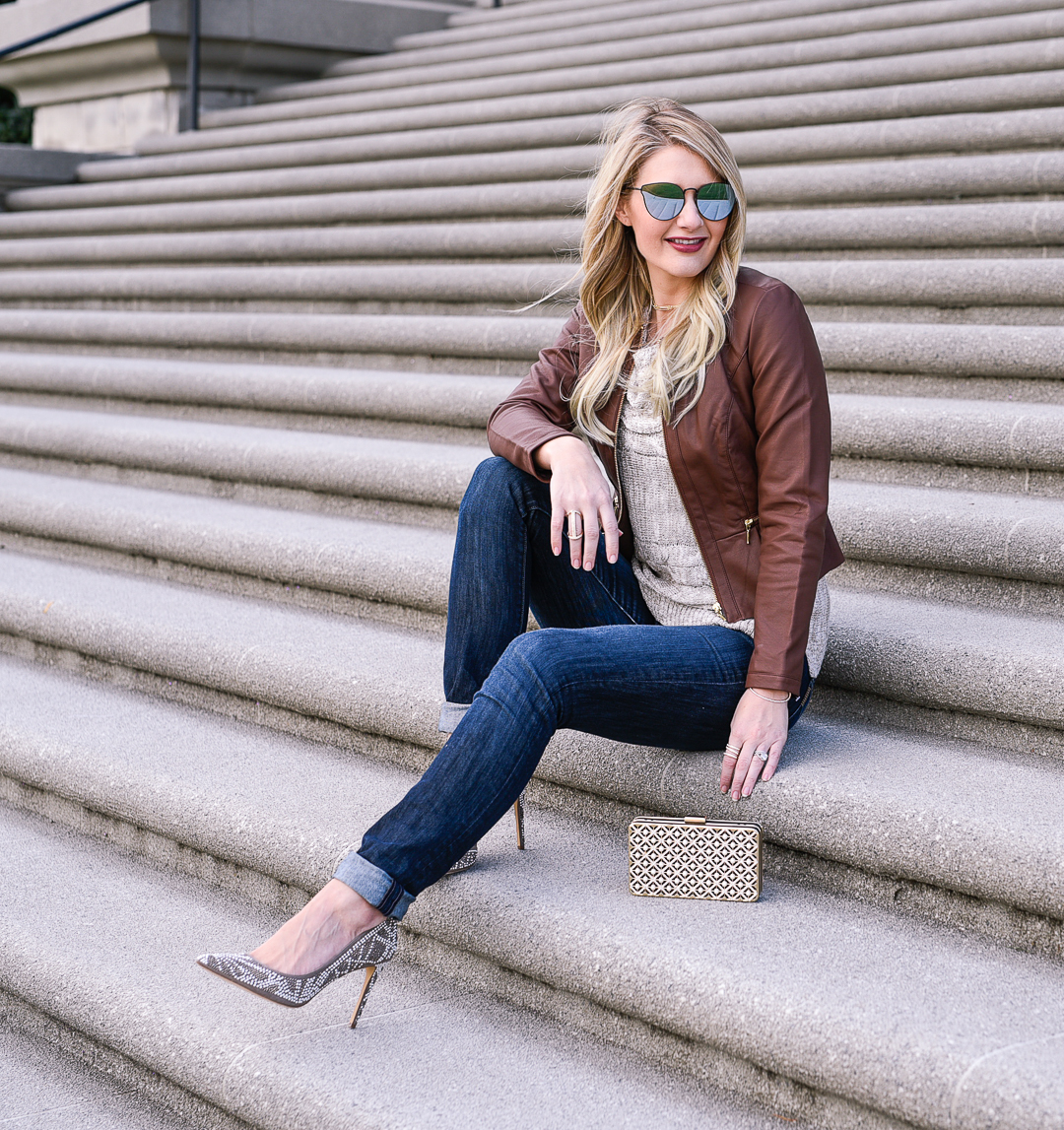 Brown leather jacket, off the shoulder sweater, and studded pumps. 