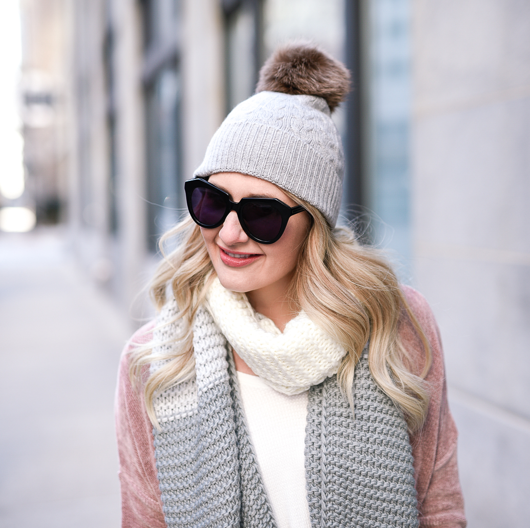 The cutest cable knit beanie with a brown fur pom accent. 