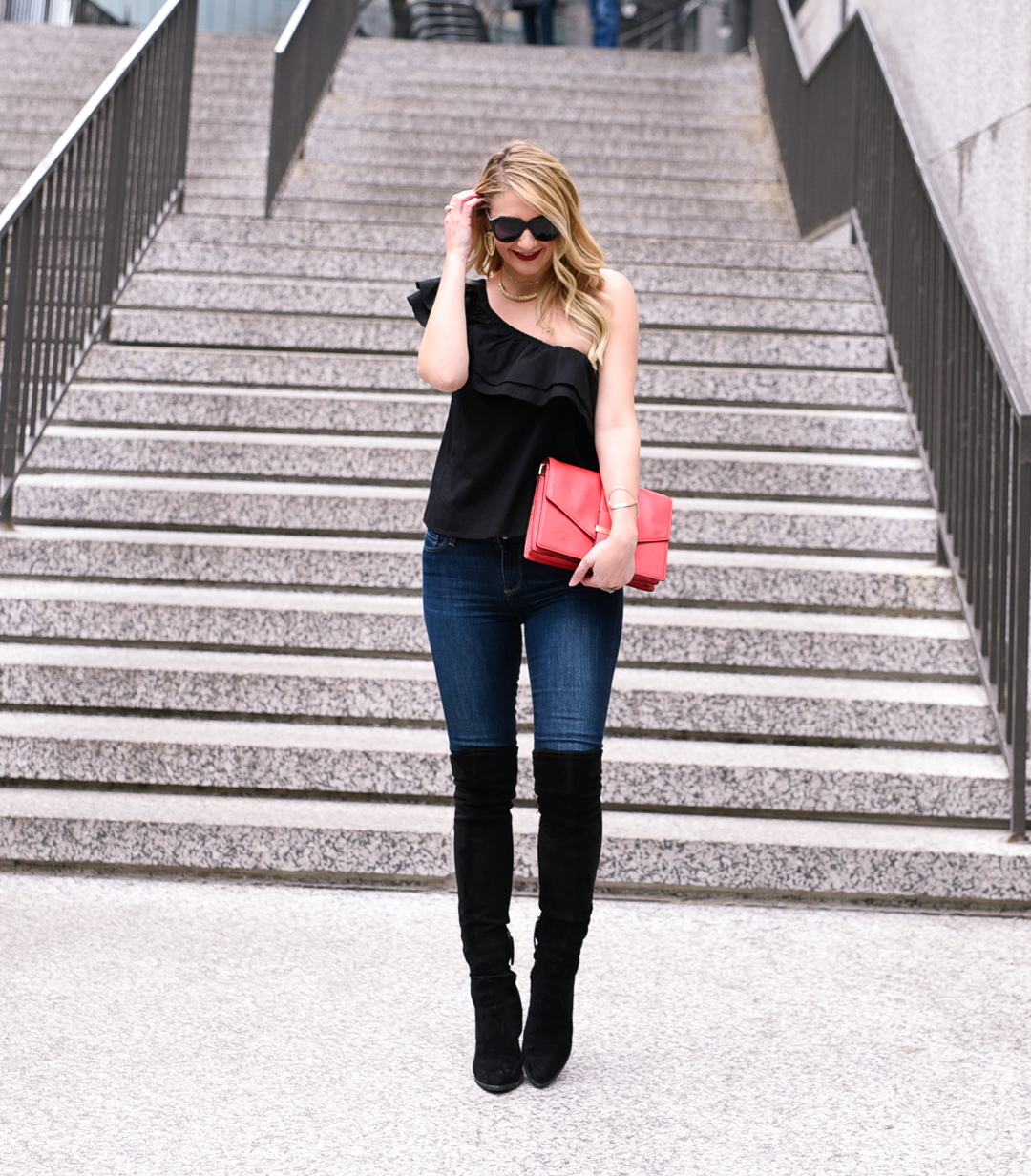 Jenna Colgrove wearing a Sincerely Jules One Shoulder Ruffle top in black with suede over the knee boots. 