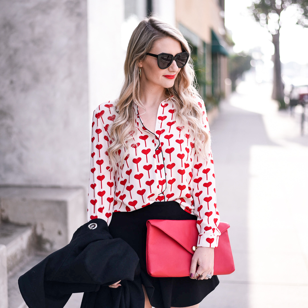 Heart printed blouse with a red envelope clutch. 