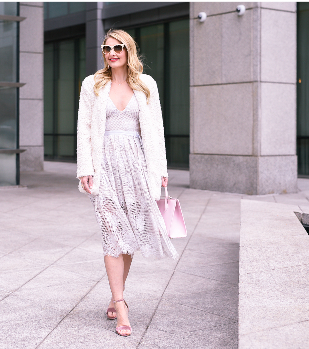 Jenna Colgrove wearing a lace Free People dress with a pink tote bag.