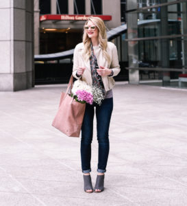 Jenna Colgrove wearing a white leather jacket with a blush leather tote bag.