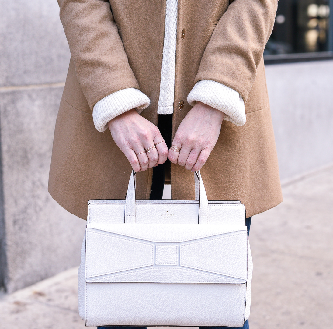 Mejuri ring stack and a Kate Spade bow bag. 