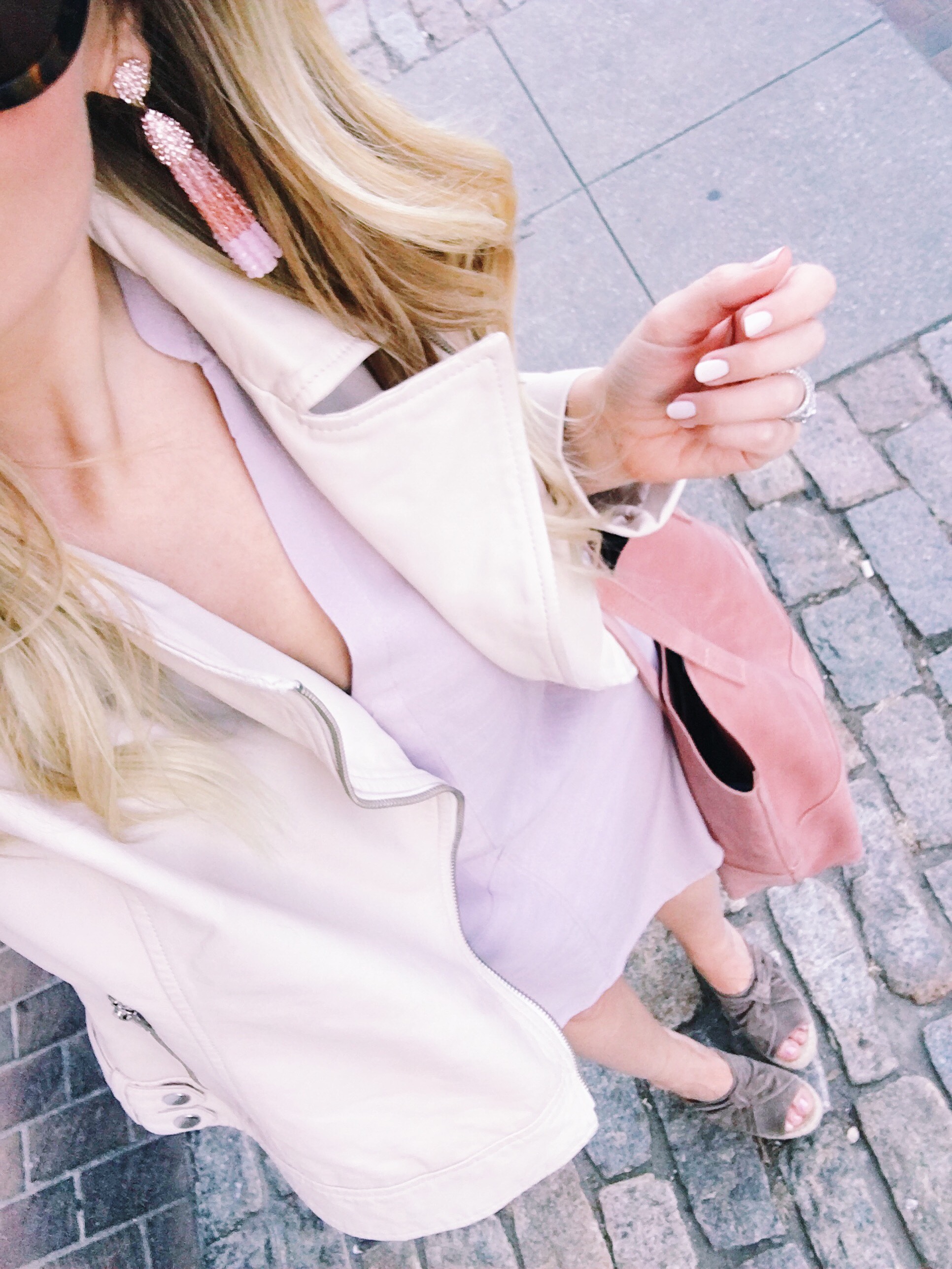 White moto jacket with a blush pink v neck shirt dress