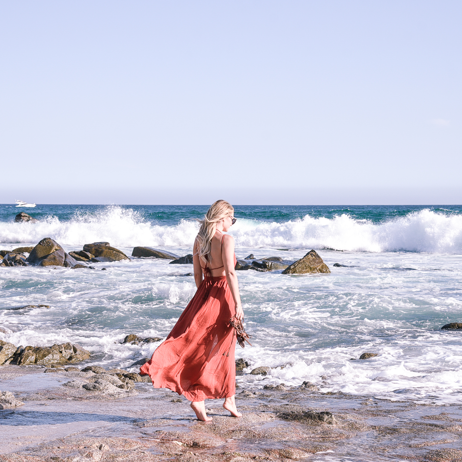 Jenna Colgrove on the beach in Cabo San Lucas, Mexico in a red maxi dress.