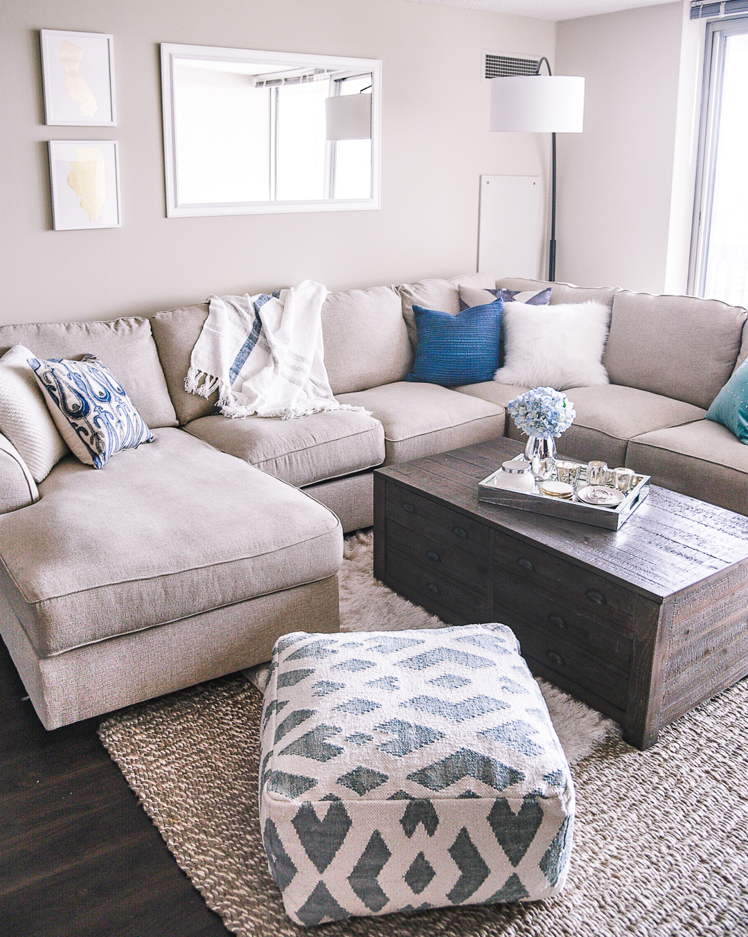 A white couch with blue textured pillows. 