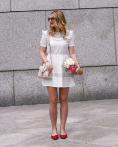 Jenna Colgrove wearing a ruffled little white dress with fresh spring flowers.
