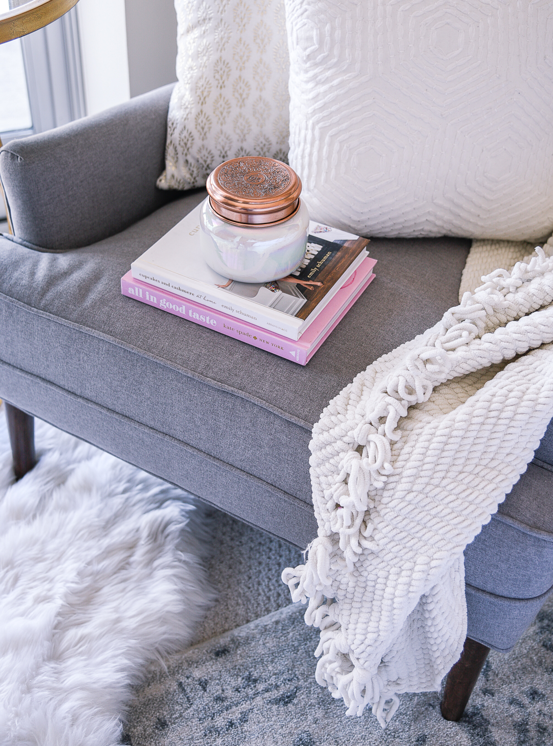 Capri Blue white and rose gold candle with a pink coffee table book. 