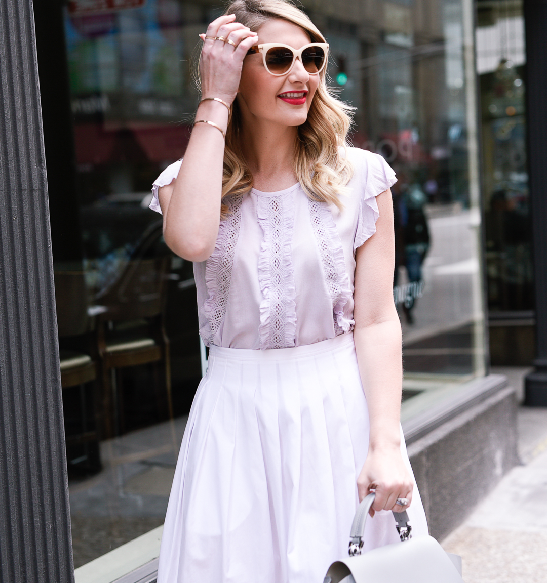 lavender ruffle and lace blouse with a high waisted pleated skirt and tom ford sunglasses