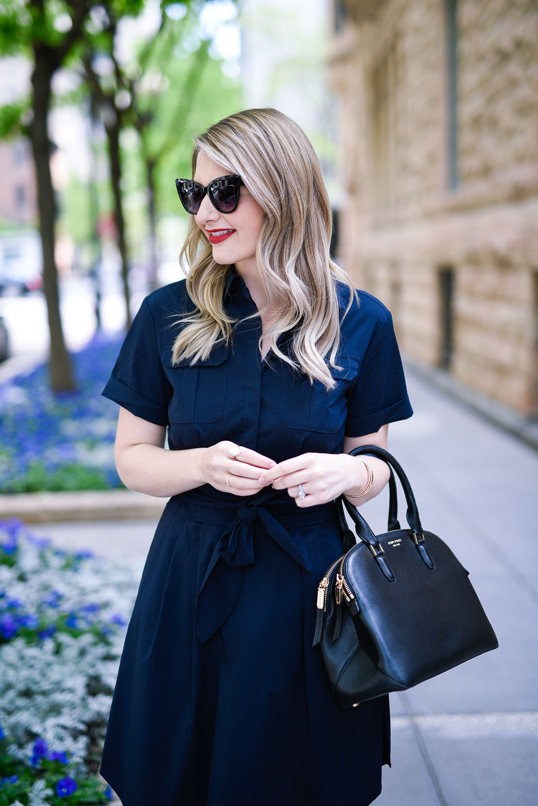 black cat eye sunglasses with a black leather satchel bag 