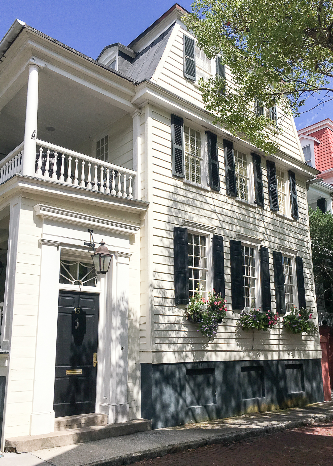 black shutters with a butter yellow house 