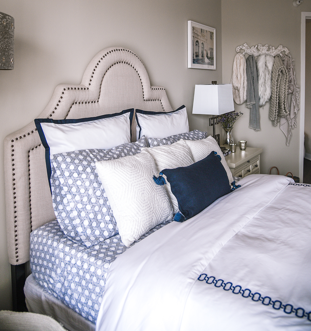 blue sateen sheets with a navy tassel throw pillow 