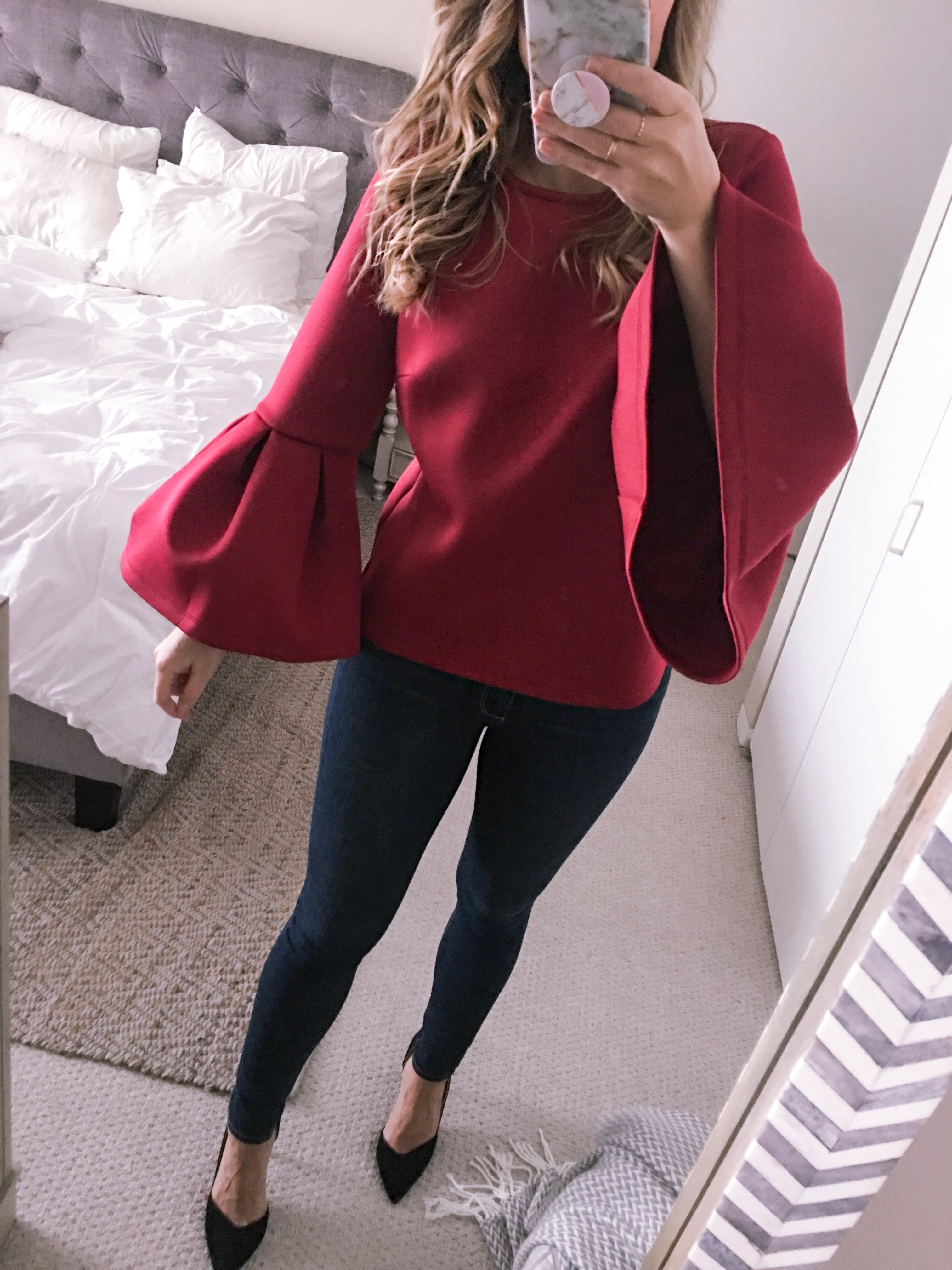 red bell sleeve top and dark wash skinny jeans