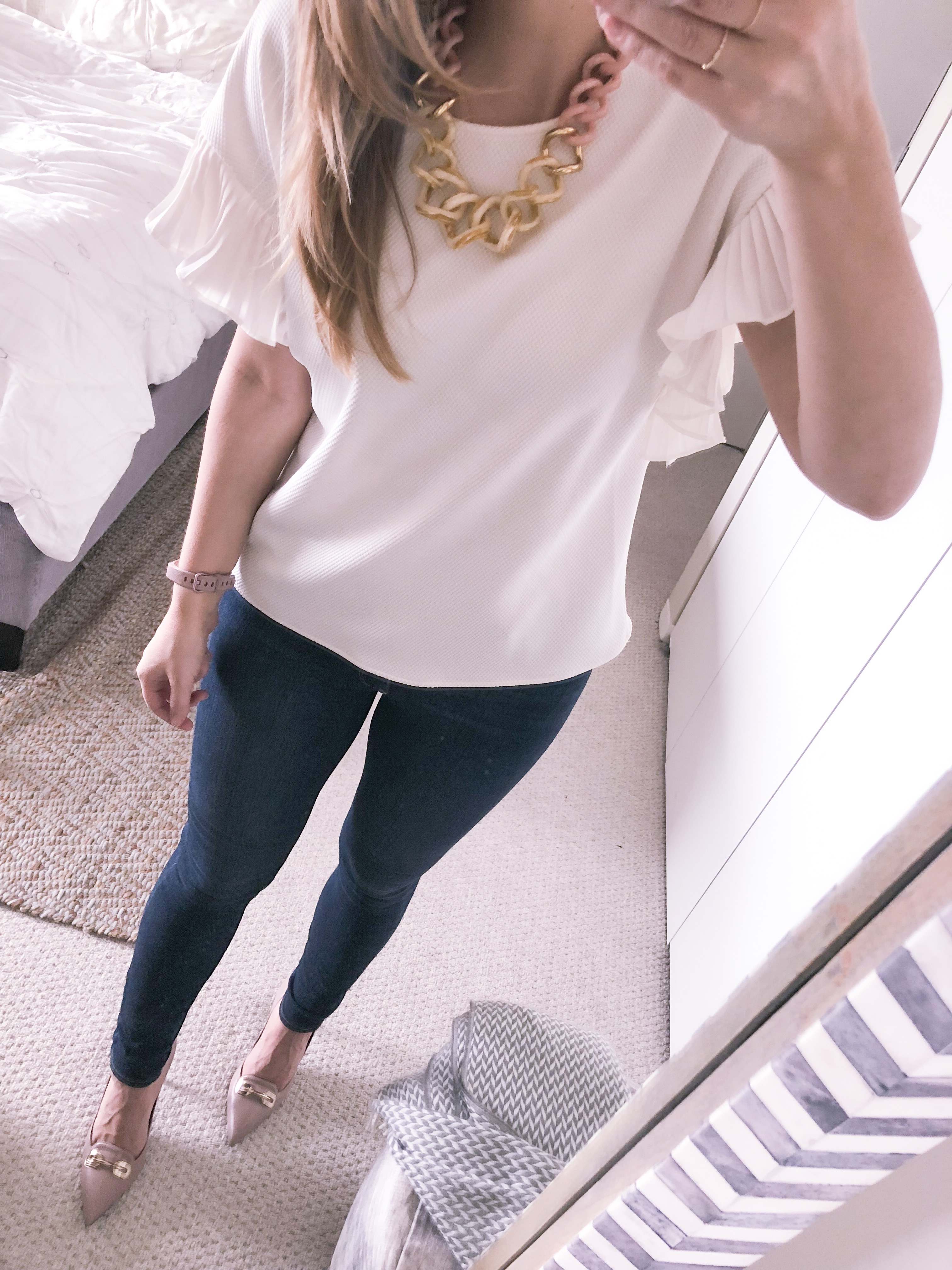 office fashion outfit idea: white ruffle sleeve top and dark wash skinny jeans