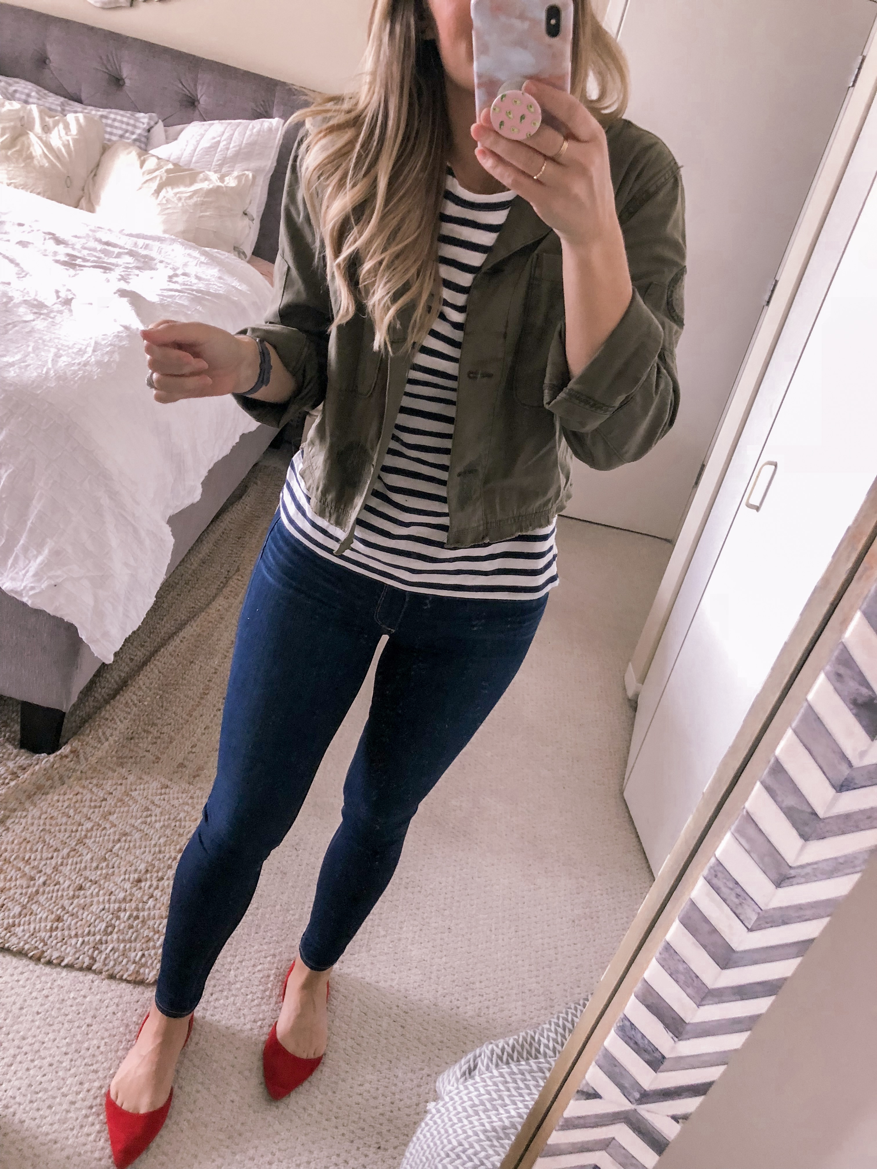 Popular Chicago fashion blogger Visions of Vogue wears a cropped olive green jacket, navy striped top and red suede flats.